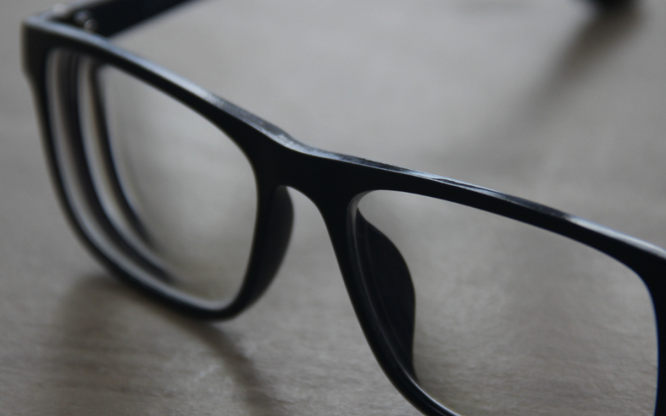 A pair of black glasses placed on a table